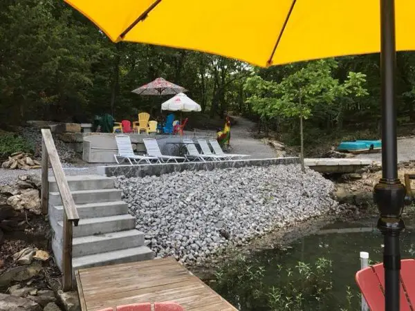 A yellow umbrella sits on a 2" x 4" Ditch Liner Rock next to a ditch liner.