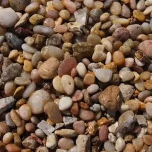 A close up view of a pile of 1.5" Alabama Sunset River Rock pebbles.