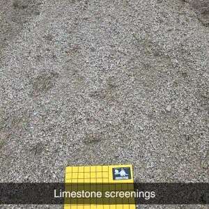 A close-up of limestone screenings with a yellow grid mat labeled "1 inch squares" placed on top. A black bar with white text reads "Limestone screenings.